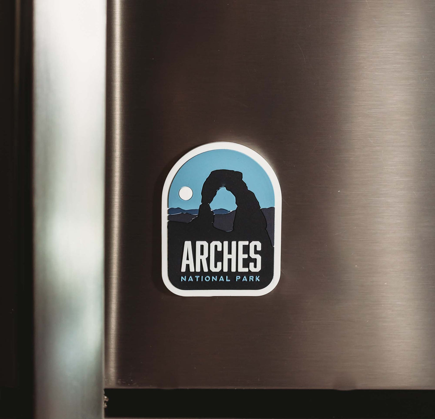 Arches National Park fridge magnet featuring a blue background and the iconic rock arch silhouette.