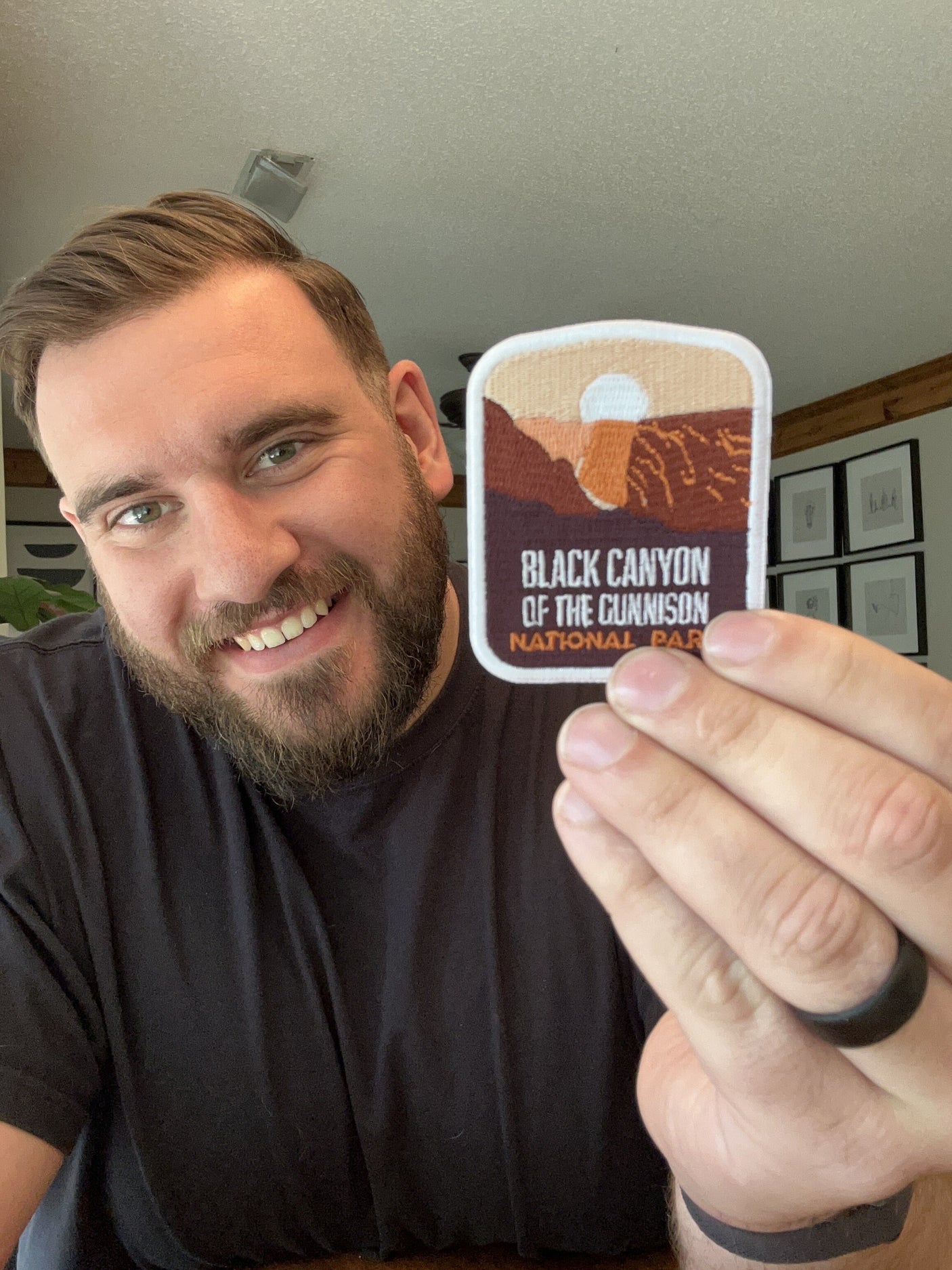 Black Canyon of the Gunnison National Park patch held by a person, featuring mountains and a sunset design.