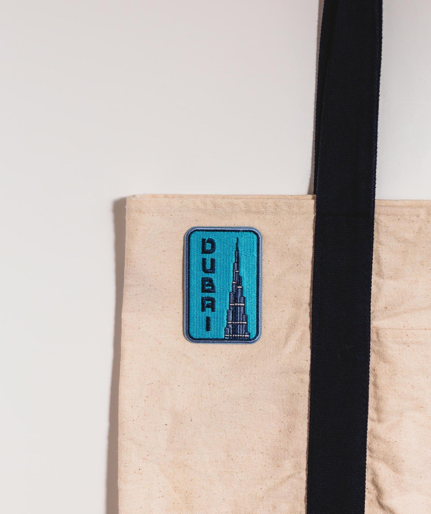 Dubai patch featuring the Burj Khalifa design on a beige tote bag.