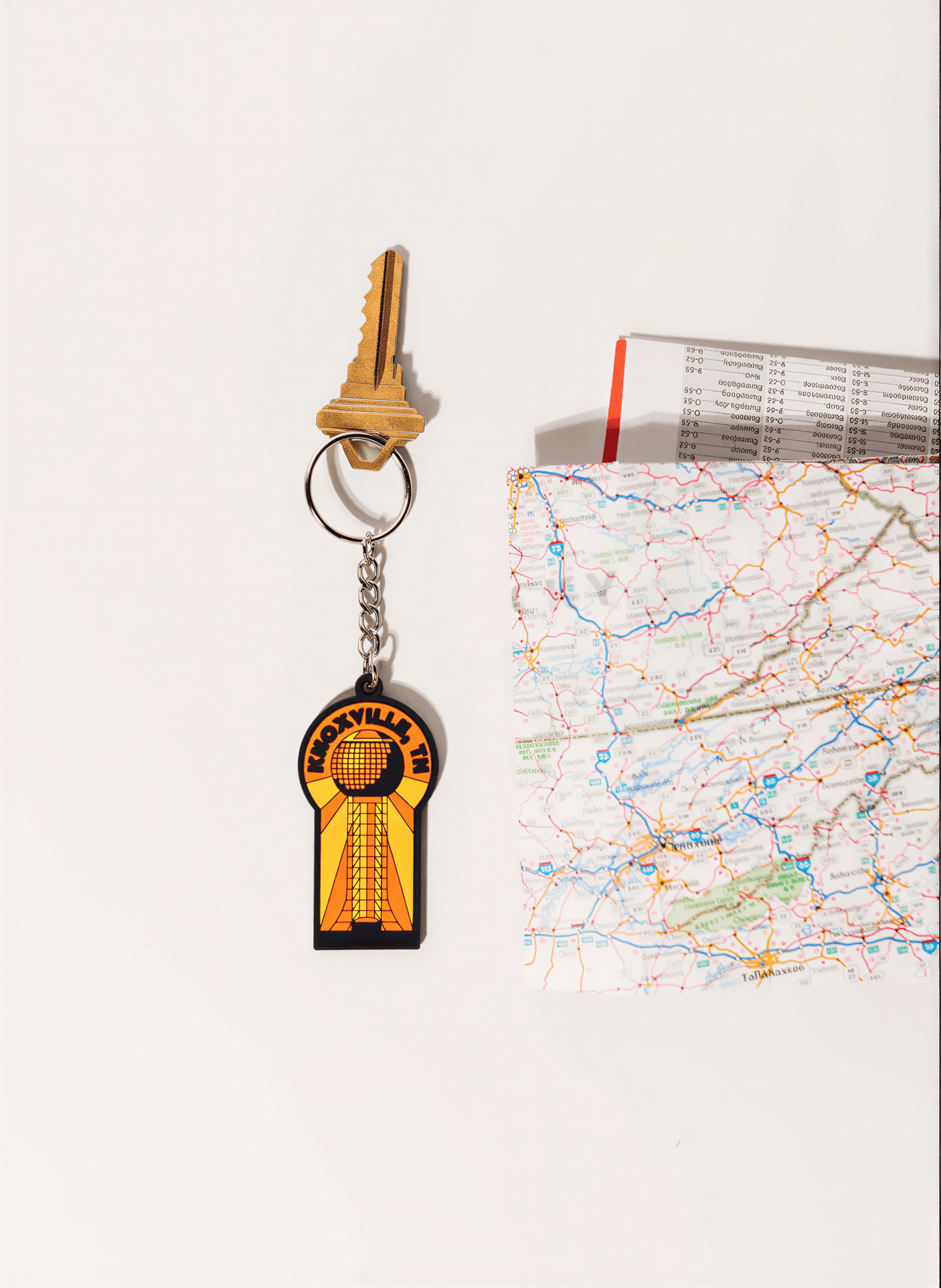 Alaska keychain featuring a colorful design with a map and a key on a white background.