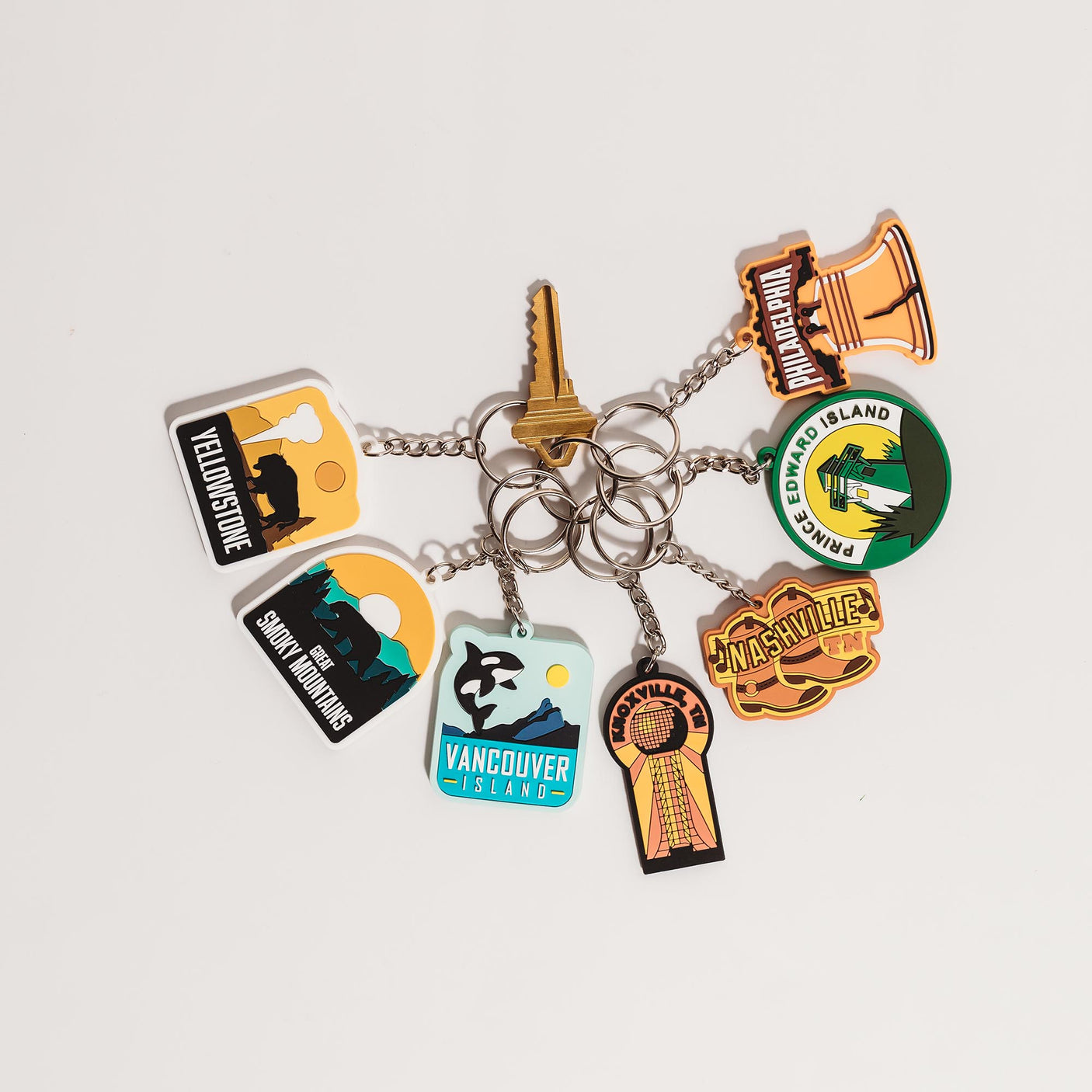Kentucky keychain featuring a colorful design with landmarks and a keyring, surrounded by other travel-themed keychains.