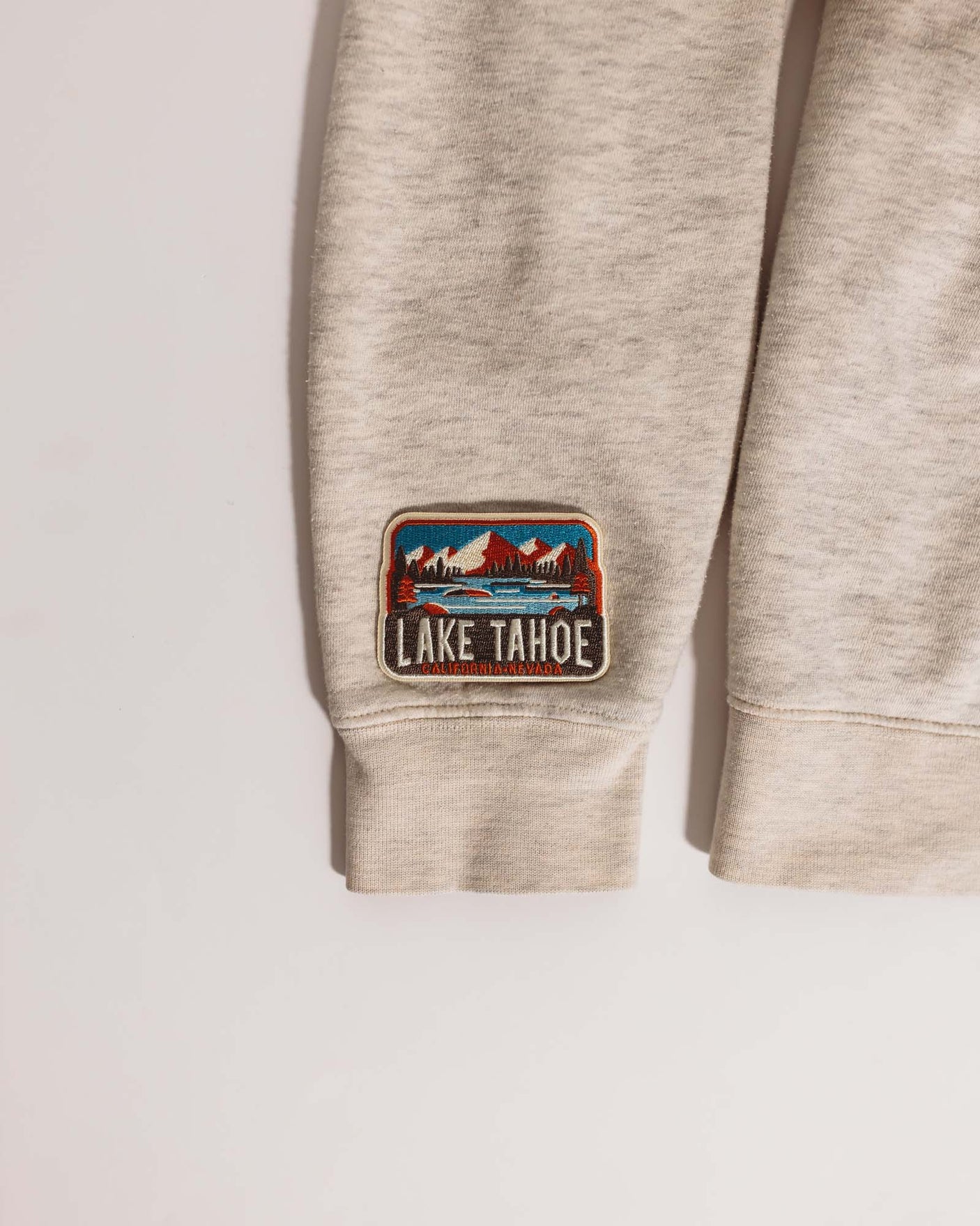 Lake Tahoe patch featuring mountains and trees with a blue sky, sewn onto a light gray fabric.