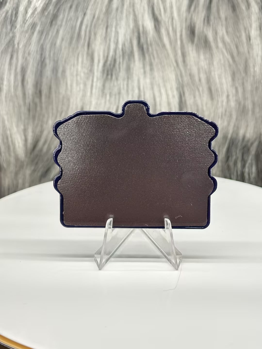 Miami Florida PVC fridge magnet with a solid dark brown back, displayed on a clear stand against a textured background.