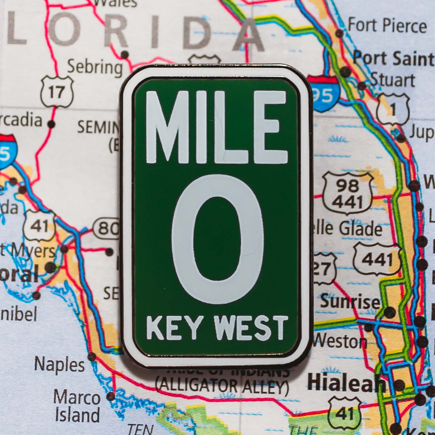 Key West Mile 0 enamel pin with a green background, white text, displayed on a Florida map.