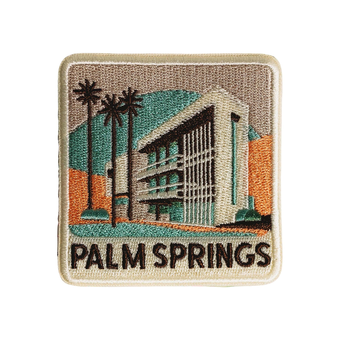 Palm Springs patch featuring a building with palm trees and mountains, in earthy tones and embroidered details.
