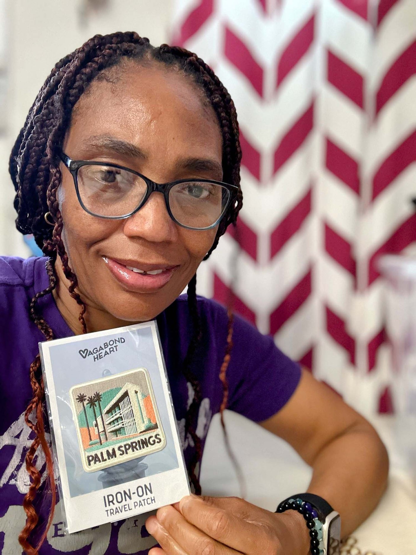 Palm Springs patch displayed by a person with braided hair, featuring a colorful design and travel patch label.