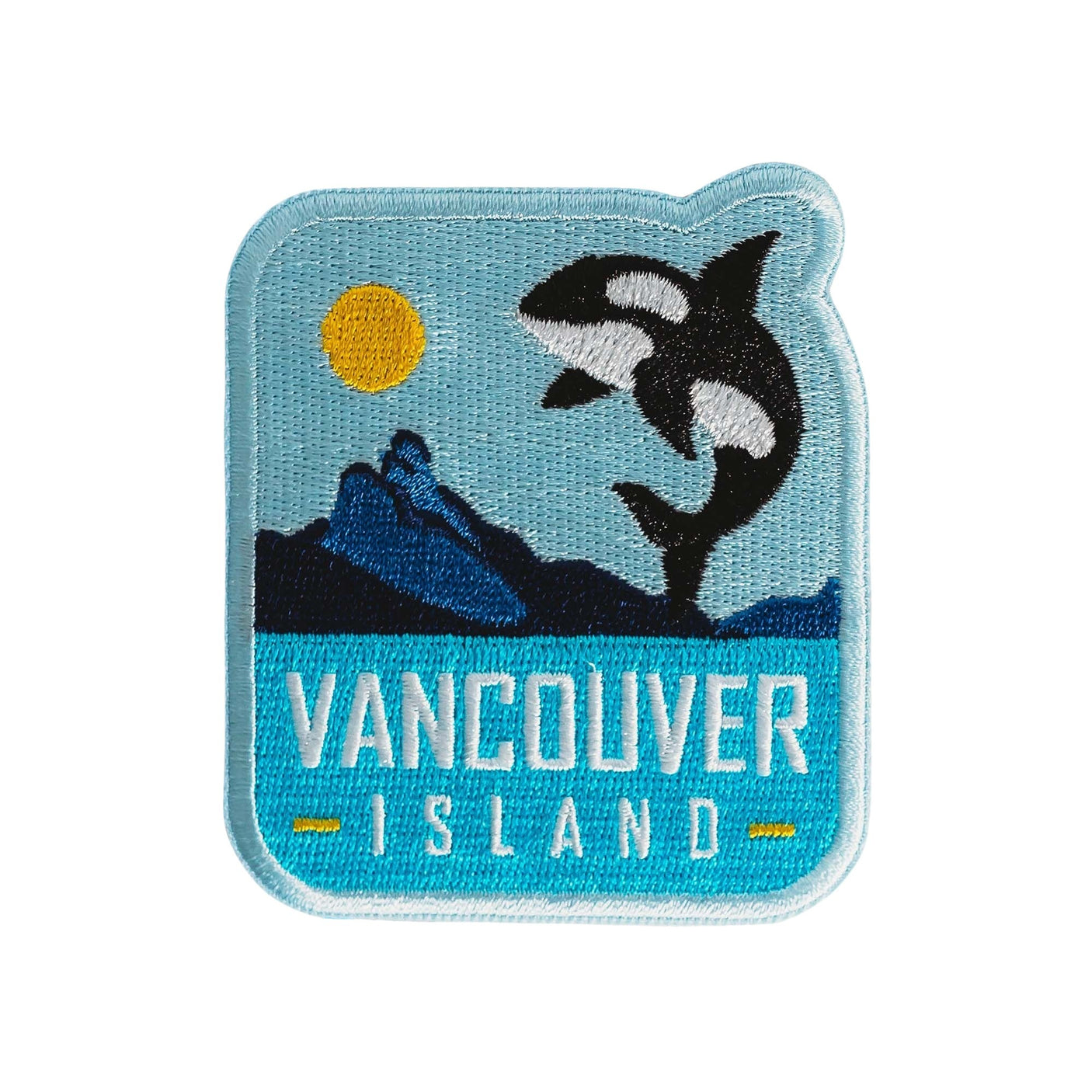 Vancouver Island patch featuring an orca jumping against a blue background with a sun and mountains.