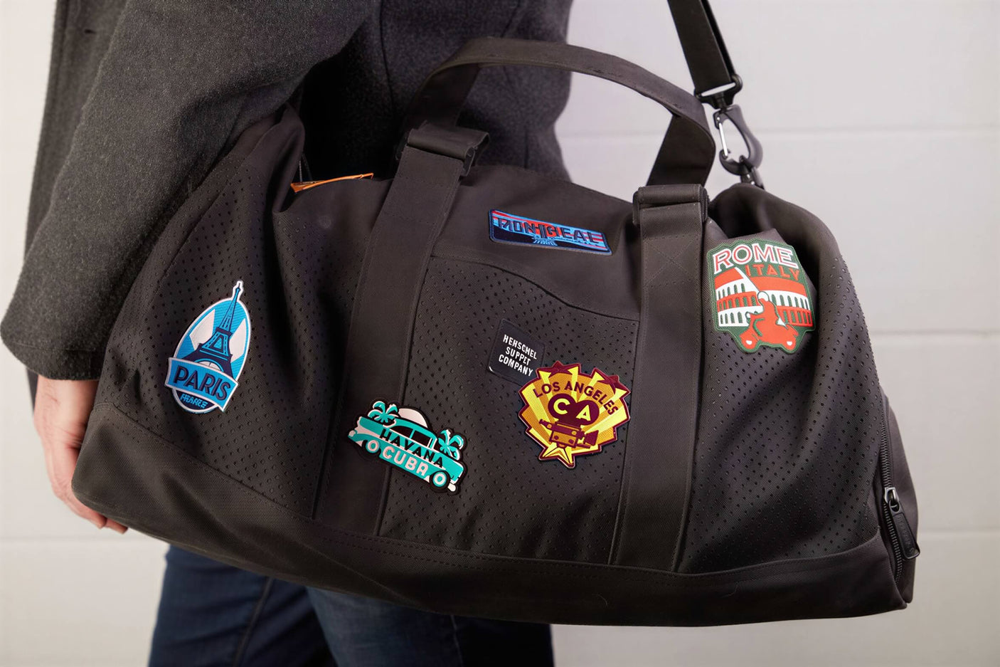 Taiwan patch on a black duffel bag alongside other travel patches from various cities.