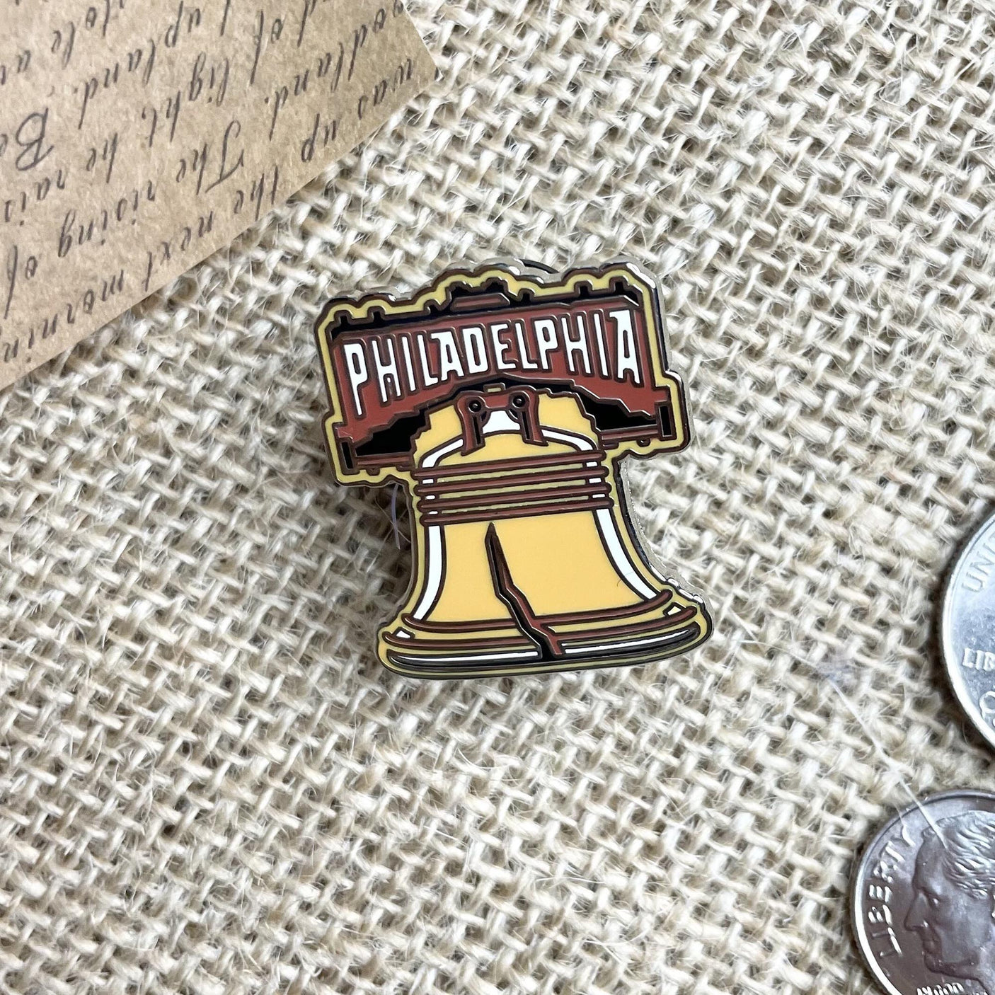 Philadelphia enamel pin featuring the Liberty Bell design with a brown and gold color scheme.