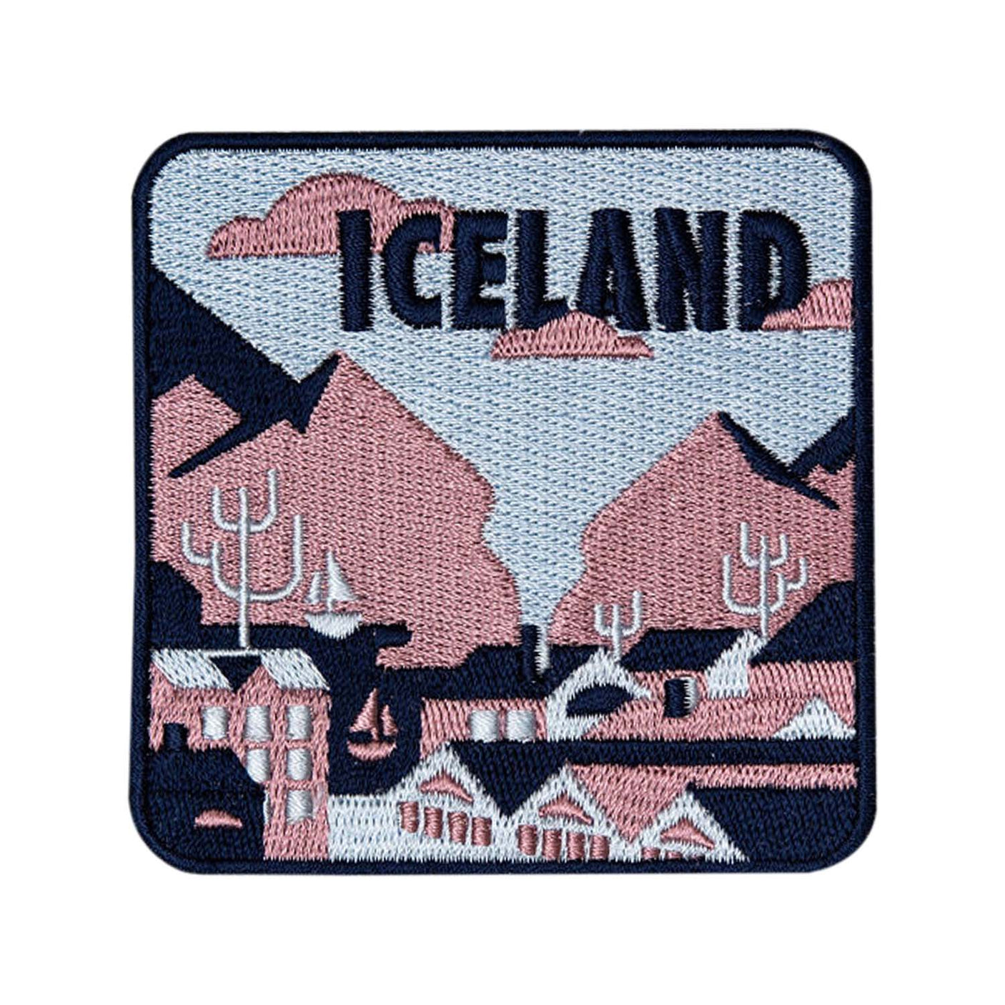Iceland patch featuring embroidered mountains, trees, and buildings in pastel colors with "ICELAND" text.