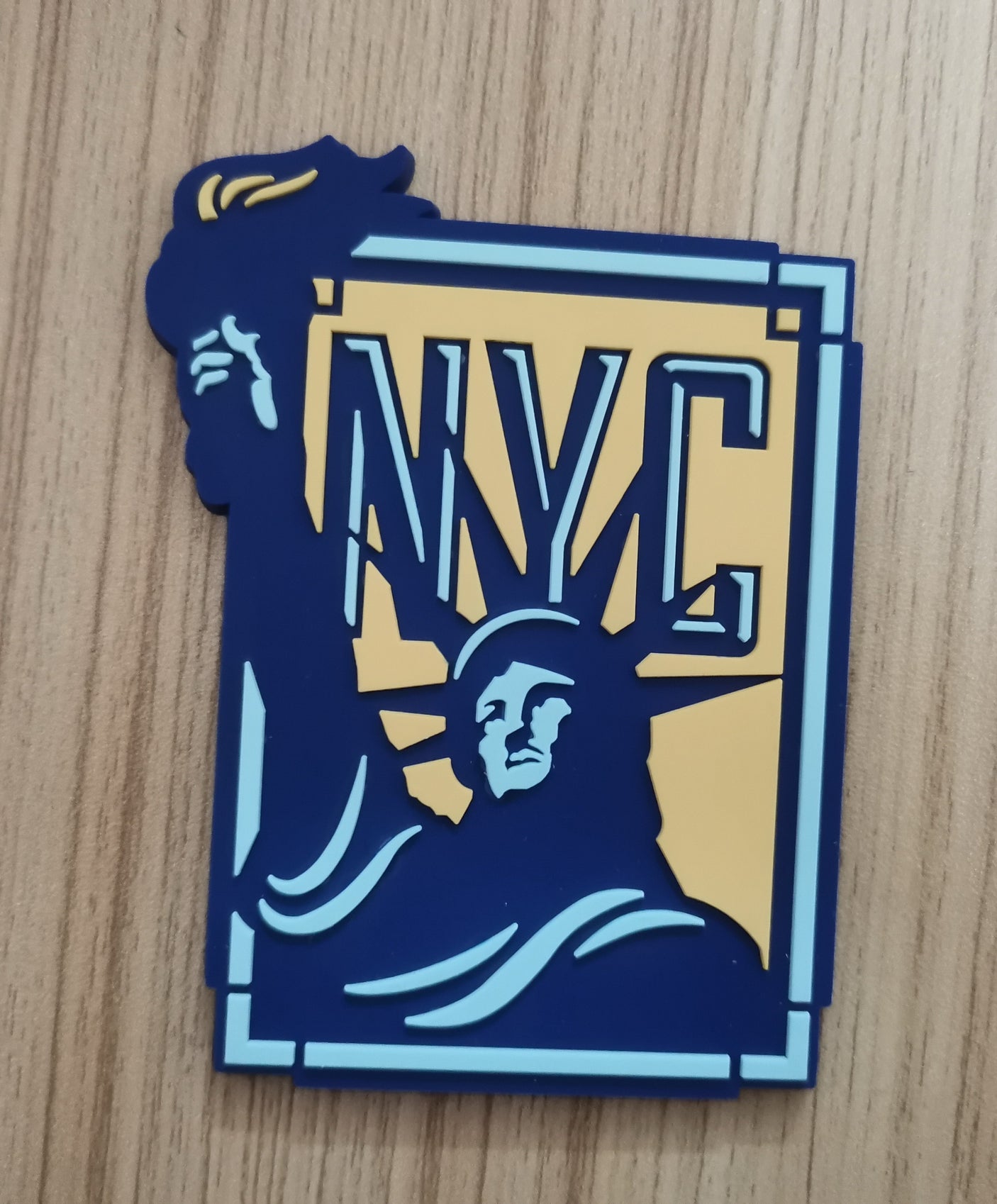 New York City PVC fridge magnet featuring the Statue of Liberty and "NYC" in blue and yellow colors.