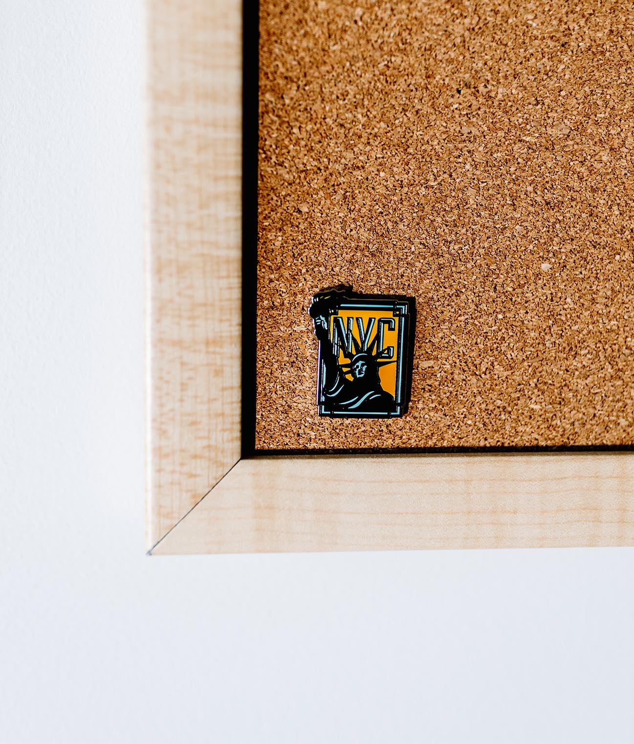 New York NYC enamel pin featuring a yellow and black design with the Statue of Liberty silhouette.