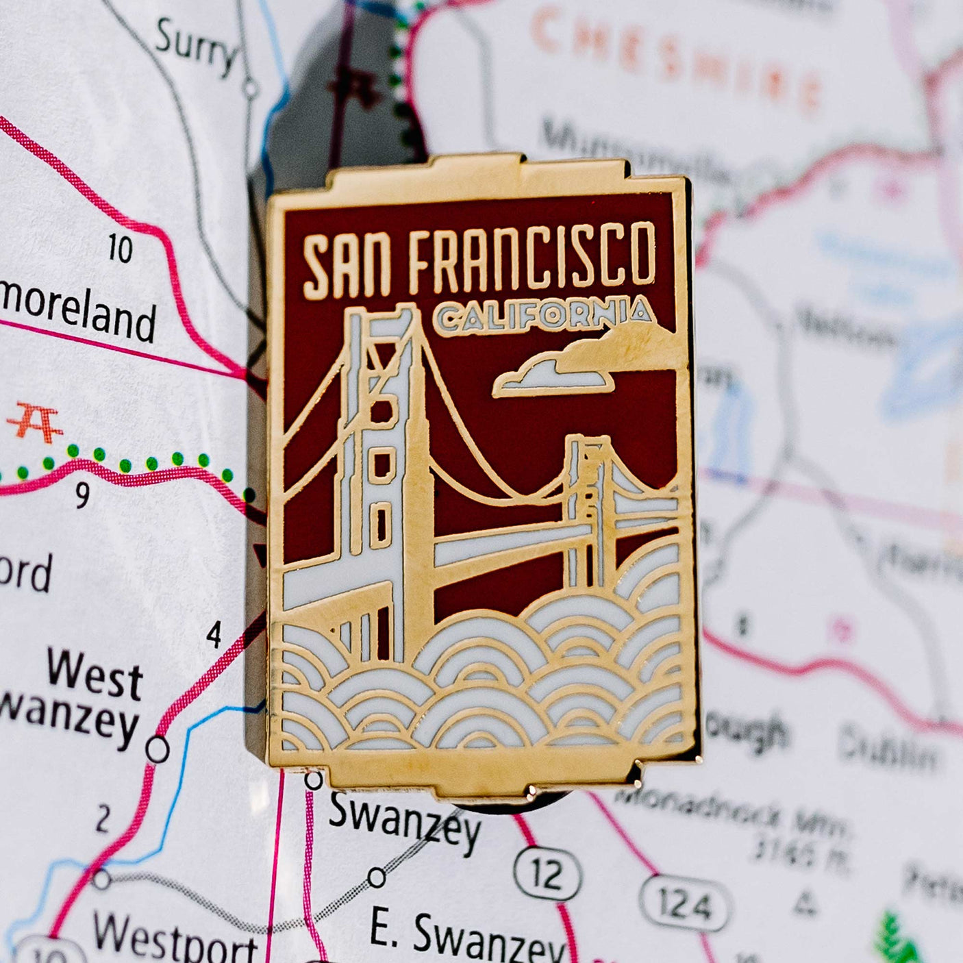 San Francisco California enamel pin featuring the Golden Gate Bridge on a map background.