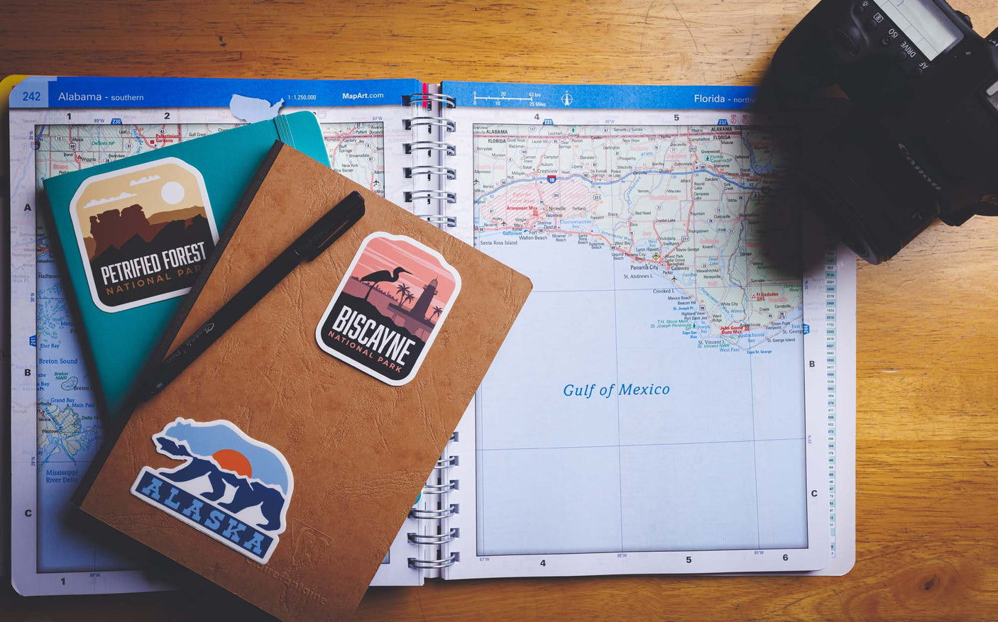 Knoxville Tennessee sticker on a notebook, surrounded by other travel-themed stickers and a map.
