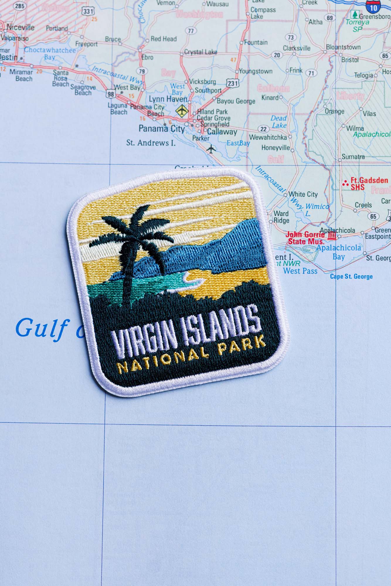 Virgin Islands National Park patch featuring a palm tree, ocean, and mountains on a blue map background.