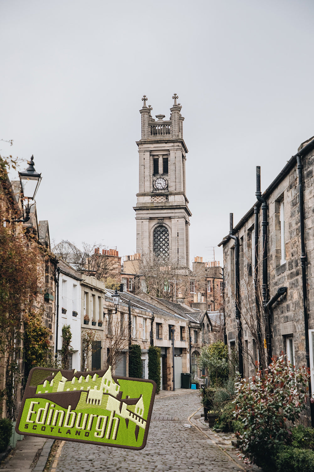 Edinburgh Scotland patch featuring a castle design, set against a cobblestone street and historic buildings.