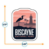 Biscayne National Park sticker featuring a heron, lighthouse, and palm trees against a sunset backdrop.