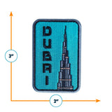 Dubai patch featuring the Burj Khalifa design, with a turquoise background and black lettering, measuring 3 inches by 2 in...