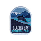 Glacier Bay National Park patch featuring a whale breaching in front of mountains and water, with blue and white colors.