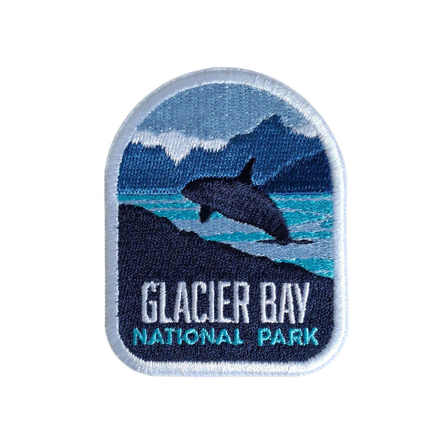 Glacier Bay National Park patch featuring a whale breaching in front of mountains and water, with blue and white colors.