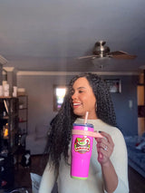 Jamaica sticker on a colorful cup held by a woman with curly hair, indoors with a soft background.