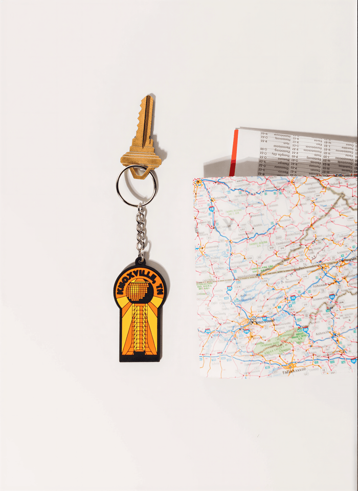 Yellowstone National Park keychain featuring a yellow and black design with a map and a key beside it.