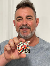 Man holding a Madagascar sticker featuring a colorful lemur design and the word "Madagascar.