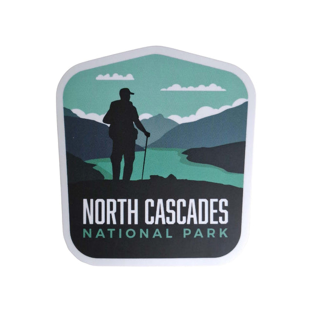 North Cascades National Park sticker featuring a hiker silhouette against mountains and a river in green and blue tones.