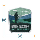 North Cascades National Park patch featuring a hiker silhouette against mountains and green landscape, measuring 2.5 inches.