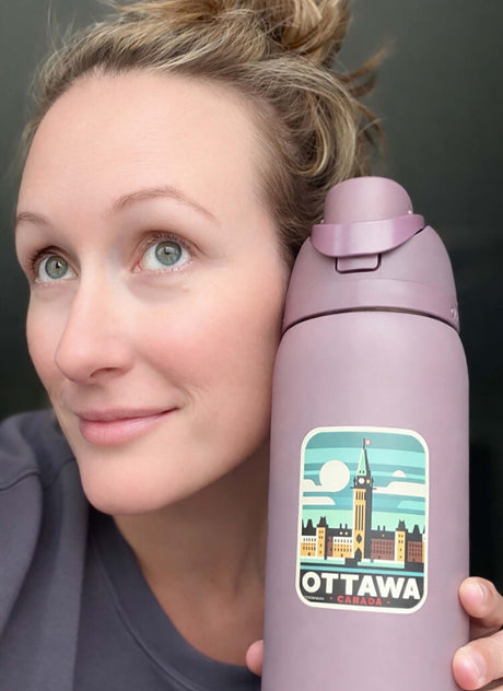 Ottawa sticker on a purple water bottle, featuring a skyline with the Peace Tower and clouds.