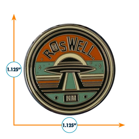 Roswell, NM enamel pin featuring a UFO design with orange, teal, and gold colors, measuring 1.125 inches in diameter.