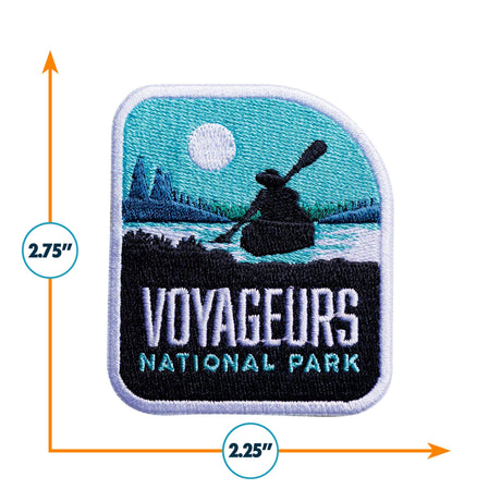 Voyageurs National Park patch featuring a canoe silhouette, mountains, and a sunlit sky, measuring 2.75 by 2.25 inches.