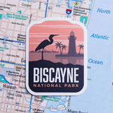 Biscayne National Park sticker featuring a heron silhouette and a lighthouse against a sunset background.