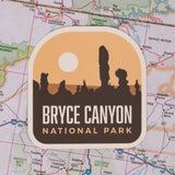 Bryce Canyon National Park sticker featuring silhouettes of rock formations against an orange sunset background.