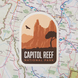 Capitol Reef National Park sticker featuring red rock formations and a silhouette of a tree on a map background.