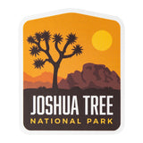 Joshua Tree National Park sticker featuring a silhouette of a tree and mountains against an orange sunset background.